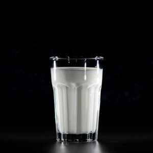 A glass of fresh milk against a black background, emphasizing simplicity and nutrition.